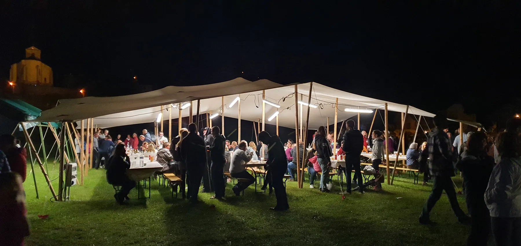 Repas sous une toile nomade éclairée, de nuit