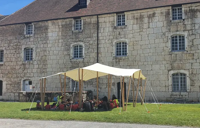 Toile tendue devant une bâtisse en pierre
