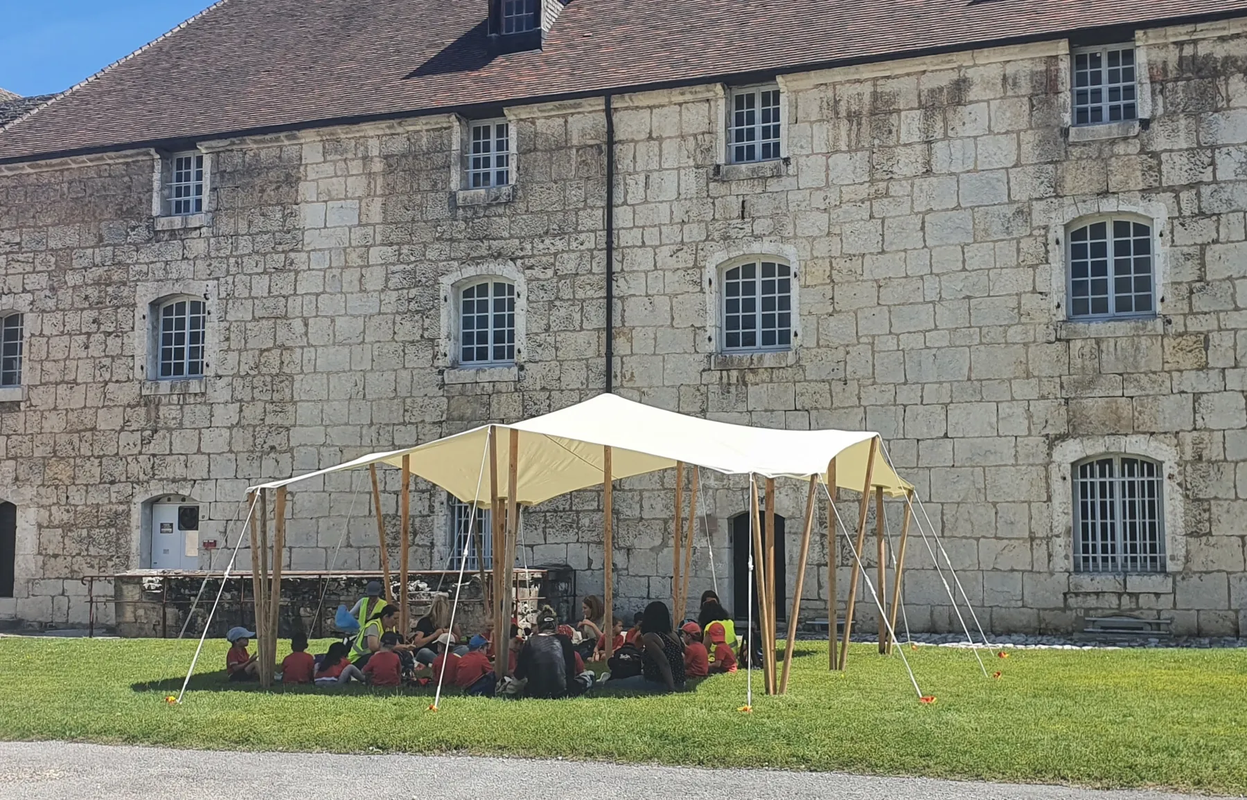 Toile tendue devant une bâtisse en pierre