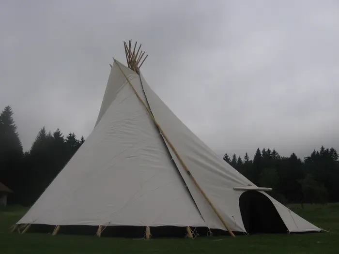 Tipi traditionnel blanc en lisière de forêt