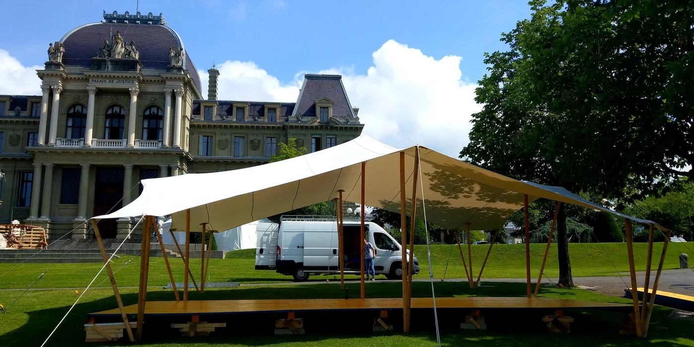 Toile nomade dressée devant un château, camion de l’atelier à côté